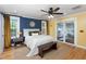 Well-lit bedroom with a blue accent wall, hardwood floors, and sliding glass doors to a deck at 212 E Rockway St, Durham, NC 27704
