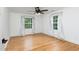 An empty bedroom with beautiful hardwood floors, two large windows, neutral walls, and white accents at 212 E Rockway St, Durham, NC 27704