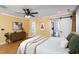 Bedroom featuring hardwood floors, yellow walls, and a glimpse into the attached bathroom at 212 E Rockway St, Durham, NC 27704