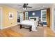 Bedroom with wood floors, a blue accent wall, and a sliding barn door to the ensuite bathroom at 212 E Rockway St, Durham, NC 27704