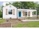 Charming white cottage with a inviting blue door, wood shutters, and manicured front yard at 212 E Rockway St, Durham, NC 27704