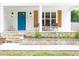 Inviting front porch with flagstone, rocking chairs, wood shutters, and a bright blue door at 212 E Rockway St, Durham, NC 27704