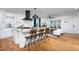 Open kitchen view with large island, wood chairs, and modern appliances blending into a comfortable living space at 212 E Rockway St, Durham, NC 27704