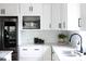 Bright kitchen featuring white cabinets, stainless steel appliances, granite counters, and subway tile backsplash at 212 E Rockway St, Durham, NC 27704