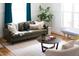 Inviting living room with green leather sofa, neutral rug, and natural light; blends style with cozy living at 212 E Rockway St, Durham, NC 27704