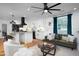 Bright living room with hardwood floors, an open kitchen, white cabinets, and modern lighting at 212 E Rockway St, Durham, NC 27704