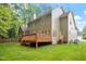 The back exterior of the home showcases large windows and a wooden patio overlooking the backyard at 216 Lewey Brook Dr, Cary, NC 27519