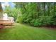 Beautiful backyard with mature trees surrounding the property, an expansive lawn, and patio access at 216 Lewey Brook Dr, Cary, NC 27519