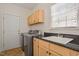 Bright laundry room with granite counters, stainless steel appliances, and ample storage at 216 Lewey Brook Dr, Cary, NC 27519