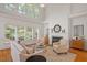 Bright living room features a fireplace, large windows, hardwood floors, and comfortable seating at 216 Lewey Brook Dr, Cary, NC 27519