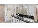 Bathroom with double sinks, dark granite countertops, and modern fixtures at 2208 Seneca Dr, Raleigh, NC 27604