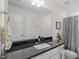 Modern bathroom featuring a granite countertop, white cabinets, and a large mirror at 2208 Seneca Dr, Raleigh, NC 27604