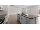 Kitchen island with stainless steel appliances, white cabinetry, granite countertops and view into living area at 2208 Seneca Dr, Raleigh, NC 27604