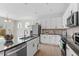 Bright kitchen features an island with black granite countertops, stainless steel appliances and white cabinets at 2208 Seneca Dr, Raleigh, NC 27604