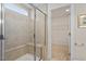 Walk-in shower with glass door, built-in bench, and tiled walls, leading to the walk-in closet at 2208 Seneca Dr, Raleigh, NC 27604