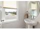 This bathroom features a stylish pedestal sink with modern fixtures and a window view at 224 Daniel Ridge Rd, Wendell, NC 27591