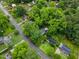 Wide aerial shot displaying the house amid a leafy neighborhood, near roads and other residences at 2324 Stevens Rd, Raleigh, NC 27610