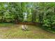 Lush backyard featuring a charming fire pit area, perfect for relaxing and entertaining surrounded by nature at 2324 Stevens Rd, Raleigh, NC 27610