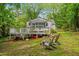 Spacious backyard view with an elevated deck, a seating area, and ample green space surrounded by trees at 2324 Stevens Rd, Raleigh, NC 27610