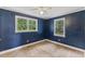 Carpeted bedroom with two windows offering natural light and blue accent walls at 2324 Stevens Rd, Raleigh, NC 27610