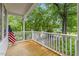 Relaxing covered front porch with new wood flooring and white railing at 2324 Stevens Rd, Raleigh, NC 27610