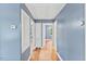 Hallway with hardwood floors, storage, and doors to the bedrooms at 2324 Stevens Rd, Raleigh, NC 27610