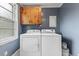 Bright laundry room featuring a white washer and dryer, wood cabinet, and natural light at 2324 Stevens Rd, Raleigh, NC 27610