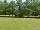 Picturesque backyard with mature trees, providing ample shade and privacy at 2436 Nc 97, Zebulon, NC 27597