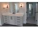 Bathroom vanity with sleek pulls, modern countertop, mirrors, and stylish lighting at 2577 Silas Peak Ln, Apex, NC 27523