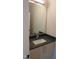 Bathroom vanity featuring a dark countertop, modern faucet, framed mirror and white cabinetry at 2577 Silas Peak Ln, Apex, NC 27523