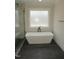 New bathroom featuring a modern freestanding tub and a frosted privacy window at 2577 Silas Peak Ln, Apex, NC 27523