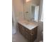 Well-lit bathroom vanity with white countertop, modern faucet, and wood-grain cabinetry at 2577 Silas Peak Ln, Apex, NC 27523
