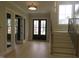 Spacious foyer with light hardwood floors, grand dark front door, and staircase at 2577 Silas Peak Ln, Apex, NC 27523