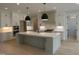 Modern kitchen with a large island, stainless steel appliances, and stylish pendant lighting at 2577 Silas Peak Ln, Apex, NC 27523