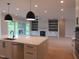 Kitchen featuring island, modern appliances and open to living room and screened porch at 2577 Silas Peak Ln, Apex, NC 27523