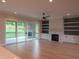 Open living room with fireplace, built-ins, and sliding glass doors to screened porch at 2577 Silas Peak Ln, Apex, NC 27523