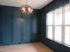 Well-lit room featuring wainscoting, a large window, and a modern light fixture at 2577 Silas Peak Ln, Apex, NC 27523