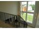 Modern staircase with metal railing and lots of natural light from adjacent windows at 2577 Silas Peak Ln, Apex, NC 27523