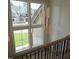 Staircase with modern hanging lights and grand windows with lawn views at 2577 Silas Peak Ln, Apex, NC 27523