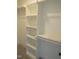 White walk-in closet with built-in shelving and neutral carpet at 2577 Silas Peak Ln, Apex, NC 27523