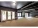 Spacious basement area with concrete ceiling, carpeted floor, and access to the backyard at 2617 Charenson Pl, Raleigh, NC 27614