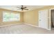 Neutral bedroom features ceiling fan, neutral carpet, and a large window with blinds at 2617 Charenson Pl, Raleigh, NC 27614