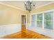 Light-filled dining room featuring hardwood floors, decorative trim, and a modern chandelier at 2617 Charenson Pl, Raleigh, NC 27614