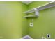 Bright laundry room features a set of shelves on a green wall with the hook-ups ready to go at 2617 Charenson Pl, Raleigh, NC 27614