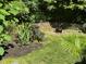 Landscaped backyard featuring lush greenery, stone accents, and a decorative water feature for a serene outdoor space at 2645 Ridgewell Ct, Raleigh, NC 27613
