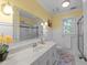 Bright bathroom featuring a shower over bath, patterned floor and view of outside greenery at 2645 Ridgewell Ct, Raleigh, NC 27613