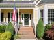 Charming front entrance with brick steps, American flag, and beautiful landscaping at 2645 Ridgewell Ct, Raleigh, NC 27613