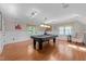 Spacious game room with hardwood floors, a pool table, and stylish lighting fixtures at 2645 Ridgewell Ct, Raleigh, NC 27613