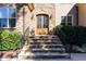 Close-up of the front door with stone steps, metal railings, and lantern-style sconces at 268 The Preserve Trl, Chapel Hill, NC 27517