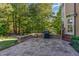 Large brick patio perfect for outdoor grilling and entertaining with a grill and serene wooded backdrop at 268 The Preserve Trl, Chapel Hill, NC 27517